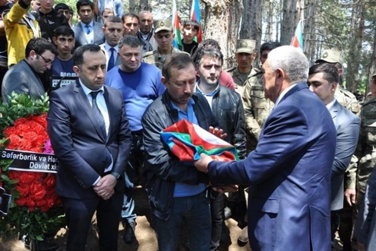 İcra başçısından bayrağa hörmətsizlik: Əzib, büküb, şəhid atasına verdi — VİDEO